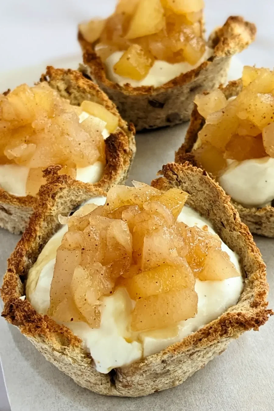 Ricotta and homemade apple sauce dessert toast cups - Muffin tin toasted bread cups with creamy ricotta filling and a generous spoonful of spiced homemade apple sauce.