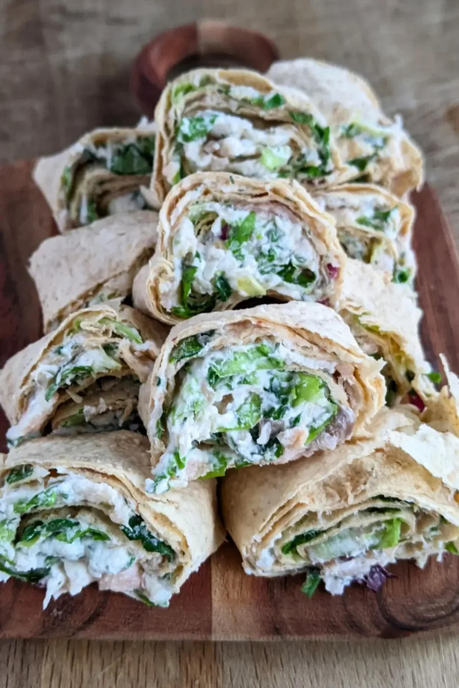 Smoked salmon flatbread appetizers sliced into pinwheels filled with salmon-cream cheese spread and fresh greens.