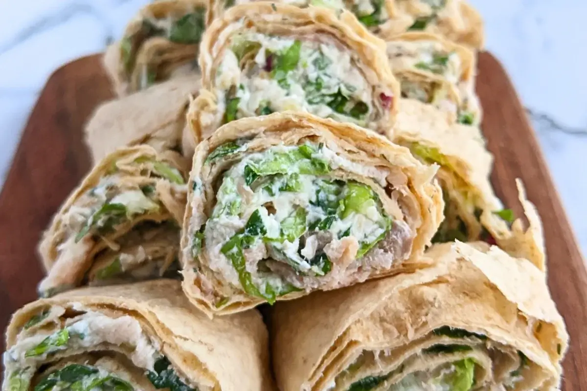 Smoked salmon flatbread appetizers sliced into pinwheels filled with salmon-cream cheese spread and fresh greens.
