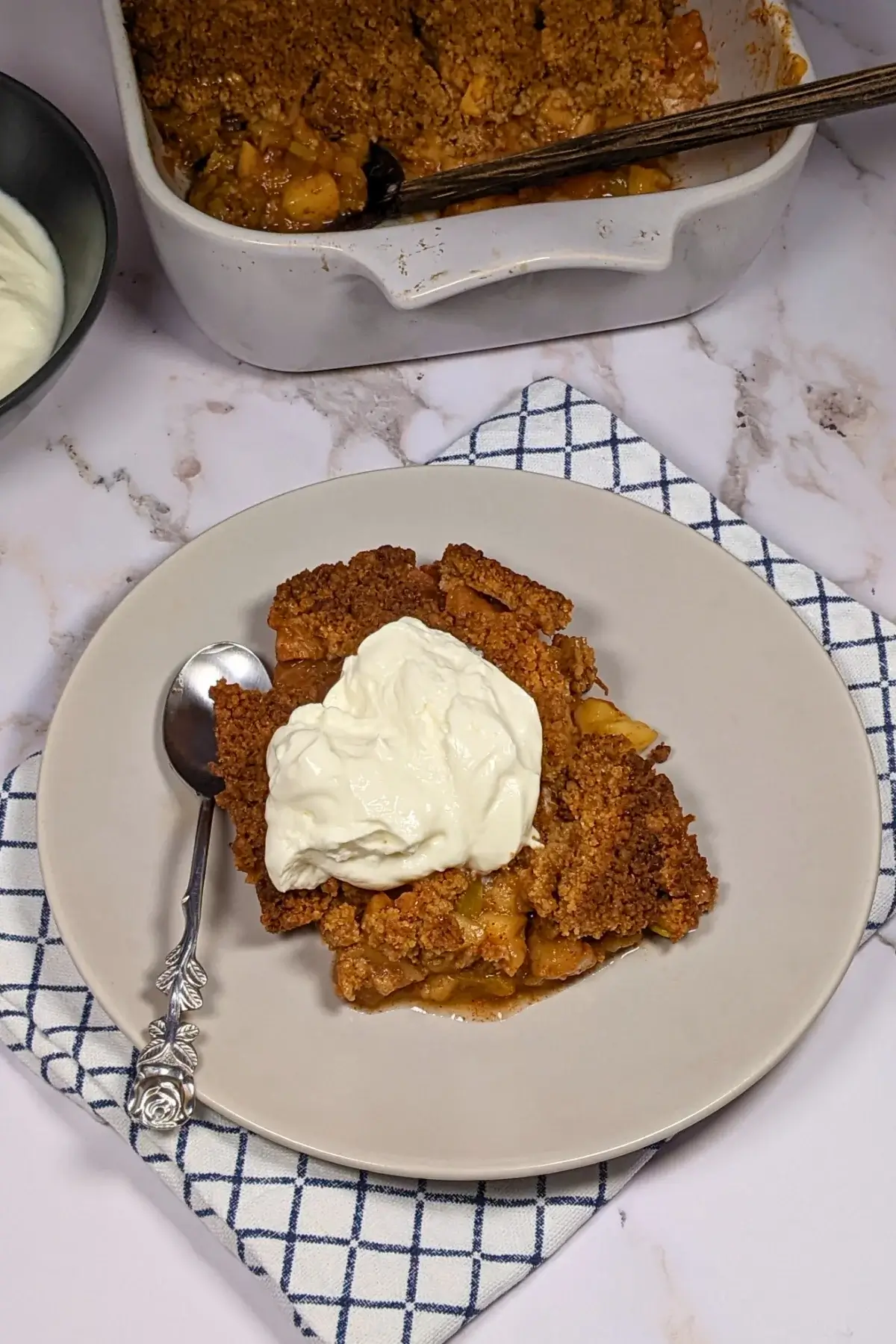 Fruit-filled apple crumble with a golden, crumbly topping and chunks of rhubarb and apple at the bottom.