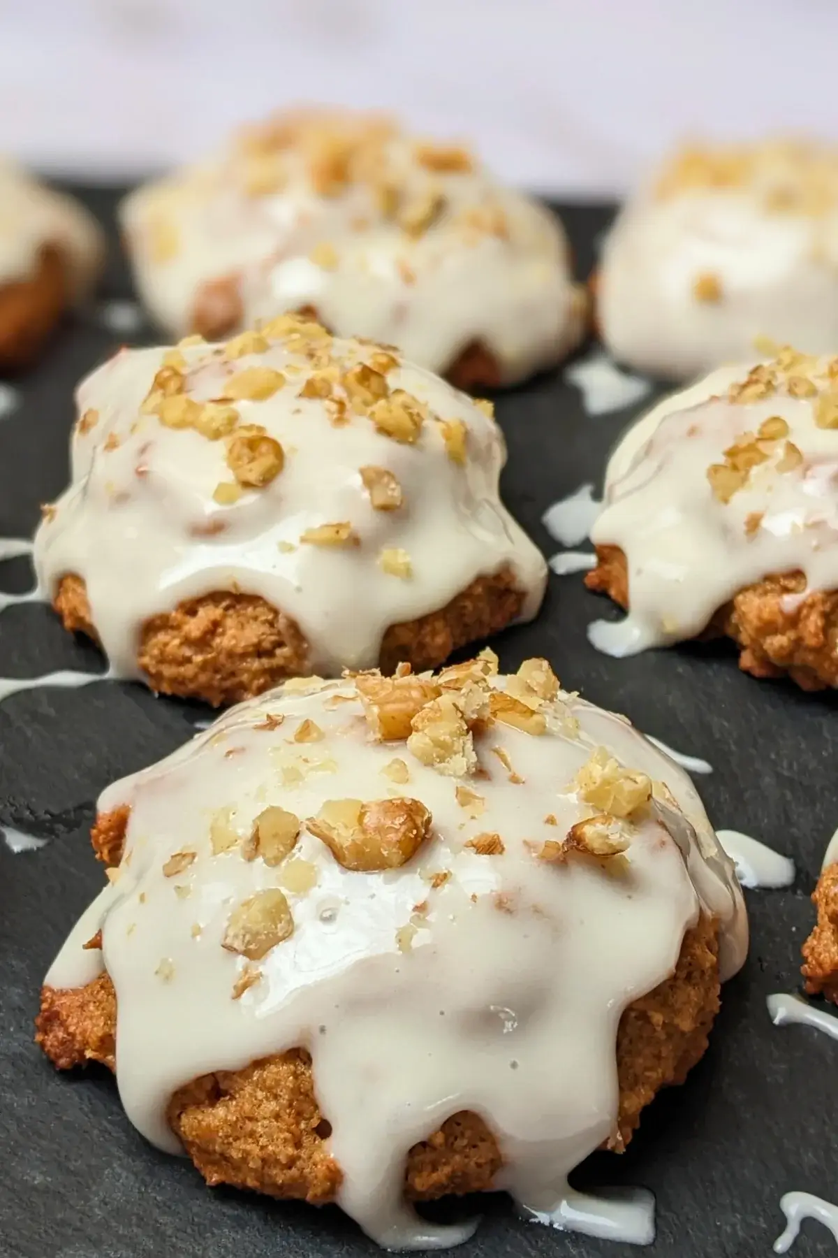 Applesauce cookies with cream cheese frosting - healthier fall cookies made with applesauce, wholemeal flour, and a mix of white and coconut sugar, topped with a cream cheese frosting and crushed walnuts.