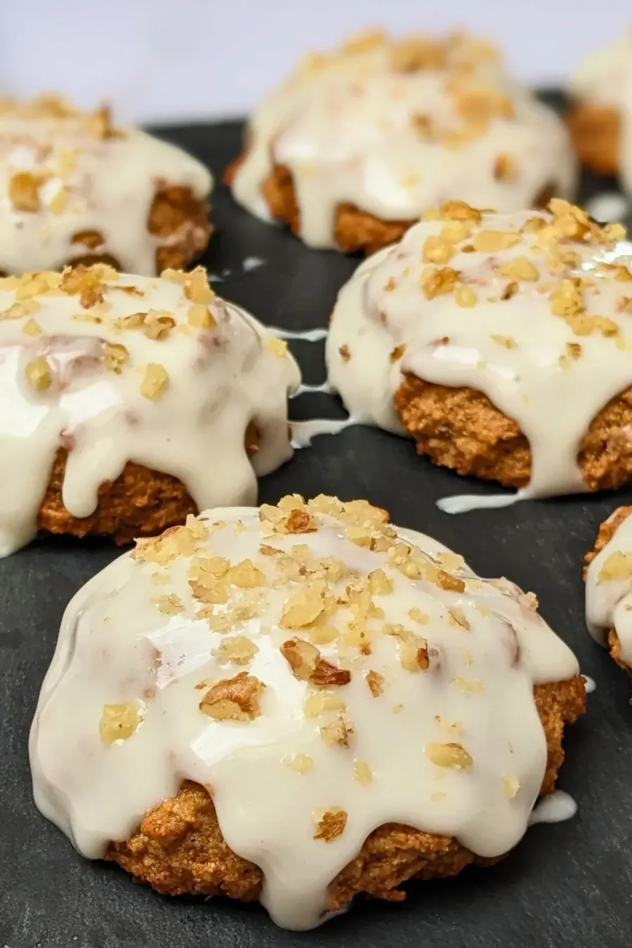 Applesauce cookies with cream cheese frosting - healthier fall cookies made with applesauce, wholemeal flour, and a mix of white and coconut sugar, topped with a cream cheese frosting and crushed walnuts.