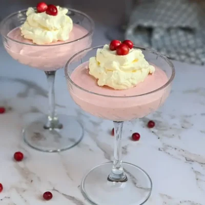 Cranberry mousse dessert - a mousse dessert made with cranberries and whipped egg whites and heavy cream, served in individual glasses.