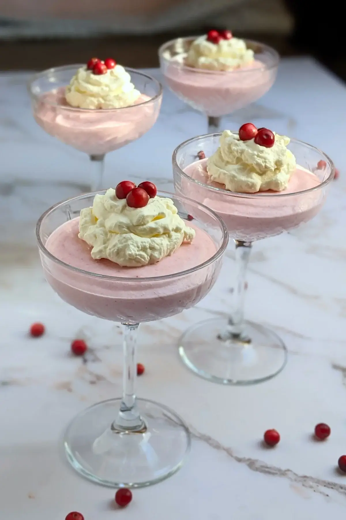 Cranberry mousse dessert - a mousse dessert made with cranberries and whipped egg whites and heavy cream, served in individual glasses.