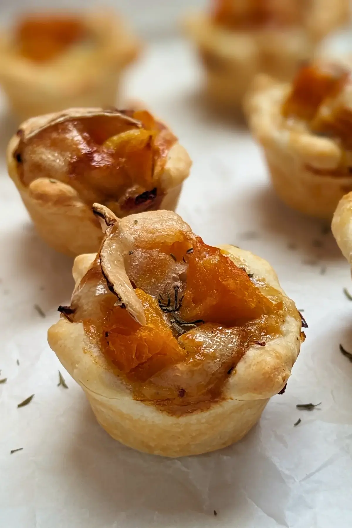 Mini Pumpkin Quiche Cups With Puff Pastry - mini quiche appetizers made in a mini muffin tin with cooked pumpkin, caramelized onions, and crispy ham in puff pastry cups.