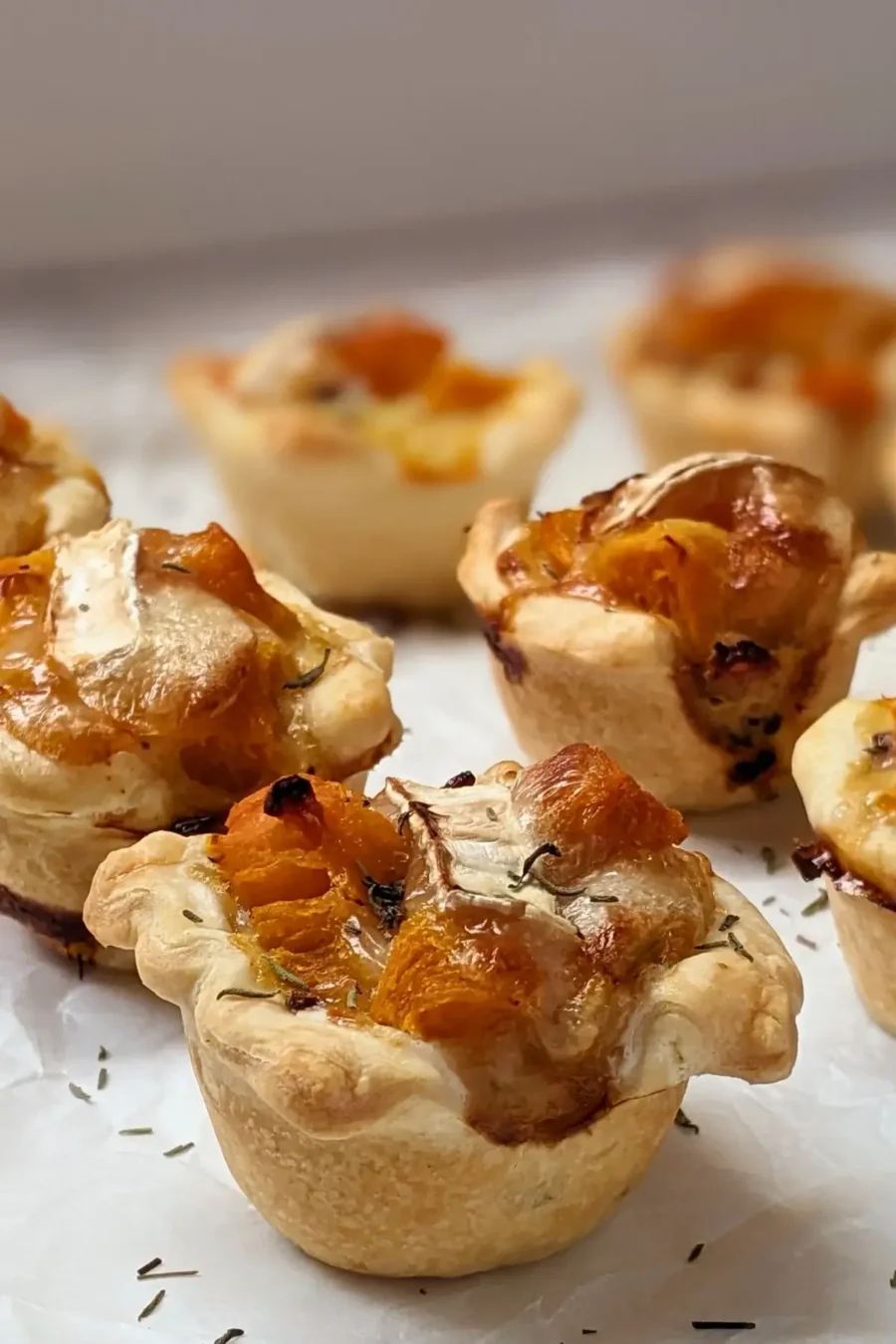 Mini Pumpkin Quiche Cups With Puff Pastry - mini quiche appetizers made in a mini muffin tin with cooked pumpkin, caramelized onions, and crispy ham in puff pastry cups.