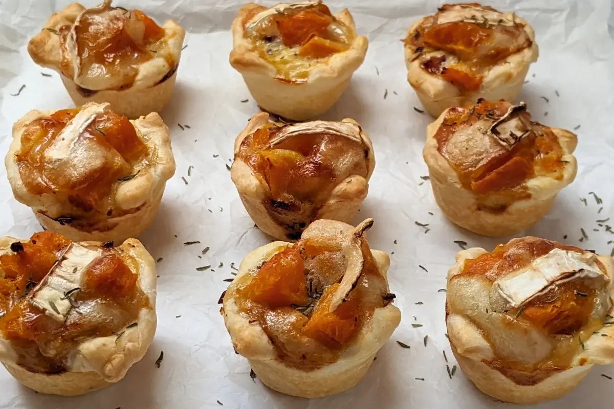Mini Pumpkin Quiche Cups With Puff Pastry - mini quiche appetizers made in a mini muffin tin with cooked pumpkin, caramelized onions, and crispy ham in puff pastry cups.