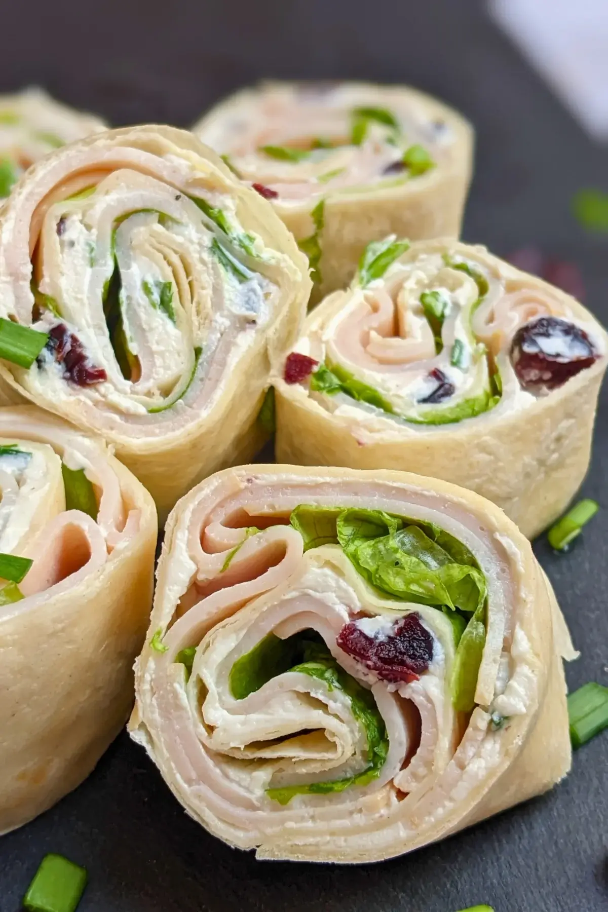 Turkey Pinwheels With Dried Cranberries - tortilla pinwheels with cream cheese filling, dried cranberries, turkey ham, and a bit of salad for color.