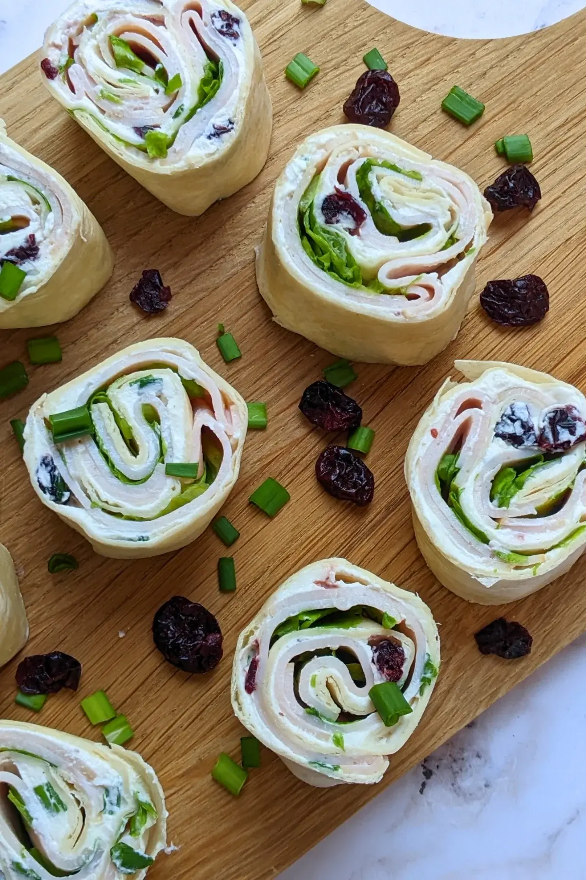 Turkey Pinwheels With Dried Cranberries - tortilla pinwheels with cream cheese filling, dried cranberries, turkey ham, and a bit of salad for color.
