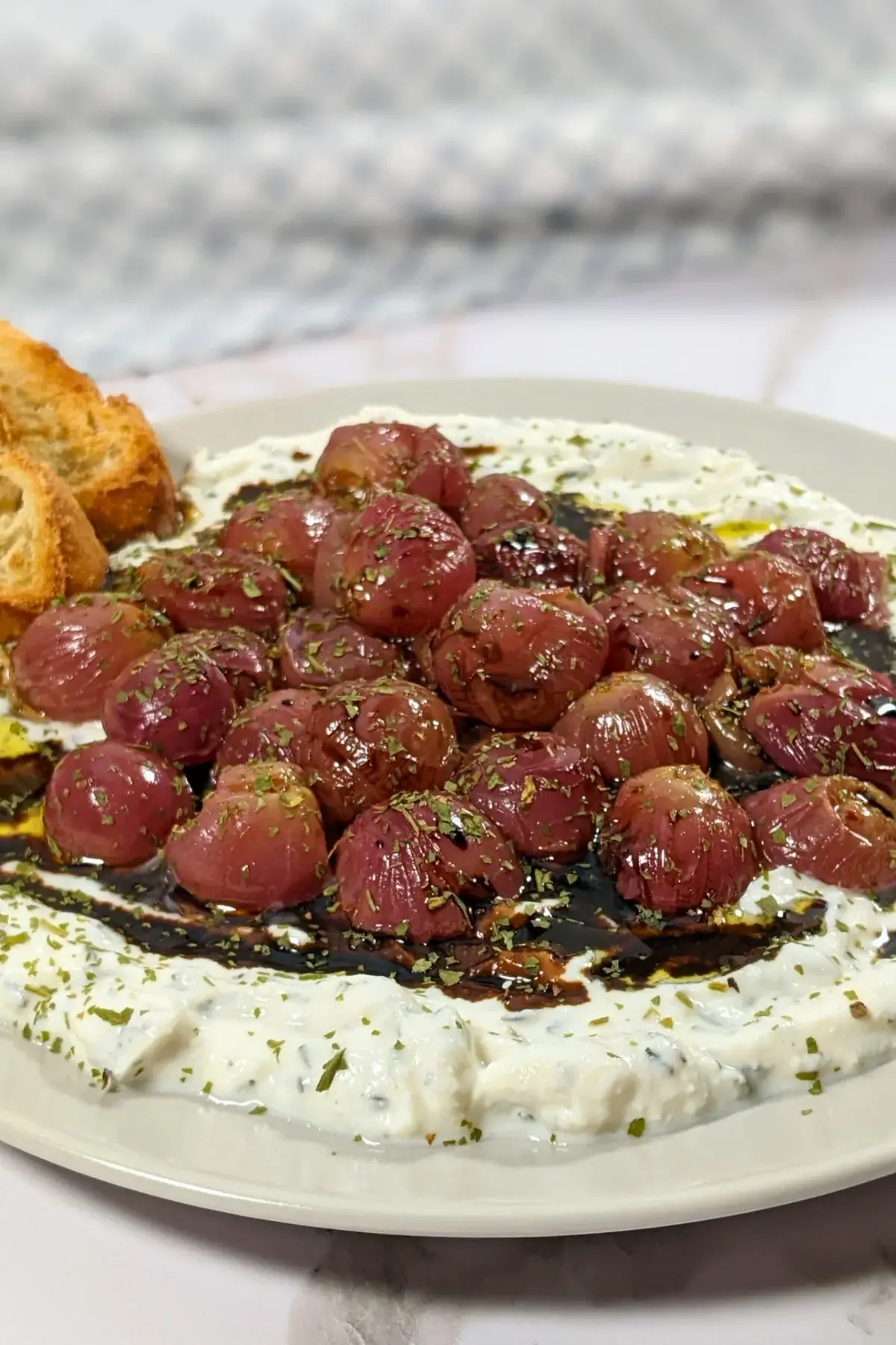 Whipped Ricotta Dip With Roasted Grapes - whipped ricotta blended with cream cheese, dried thyme, and dried garlic dip served with oven-roasted grapes on top and crispy French bread.