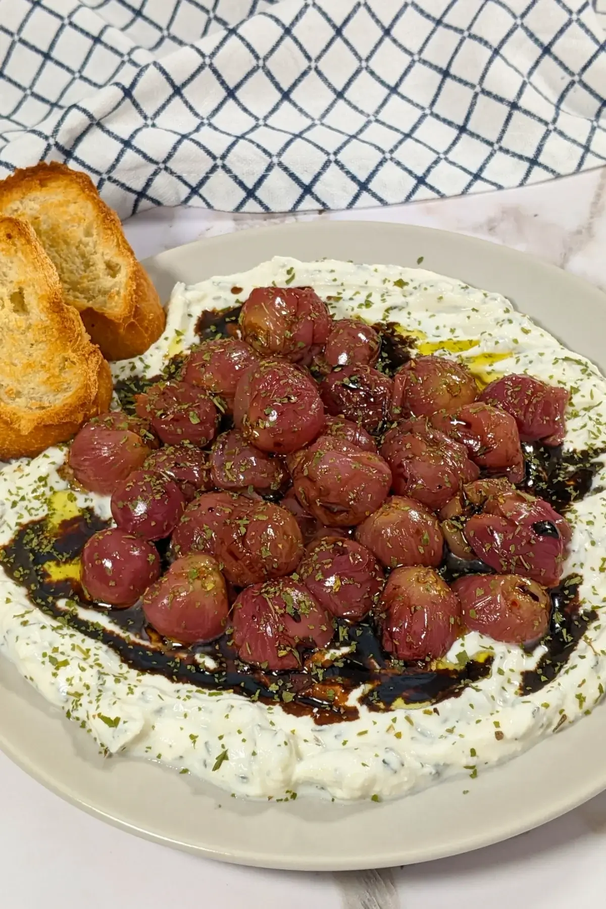 Whipped Ricotta Dip With Roasted Grapes - whipped ricotta blended with cream cheese, dried thyme, and dried garlic dip served with oven-roasted grapes on top and crispy French bread.