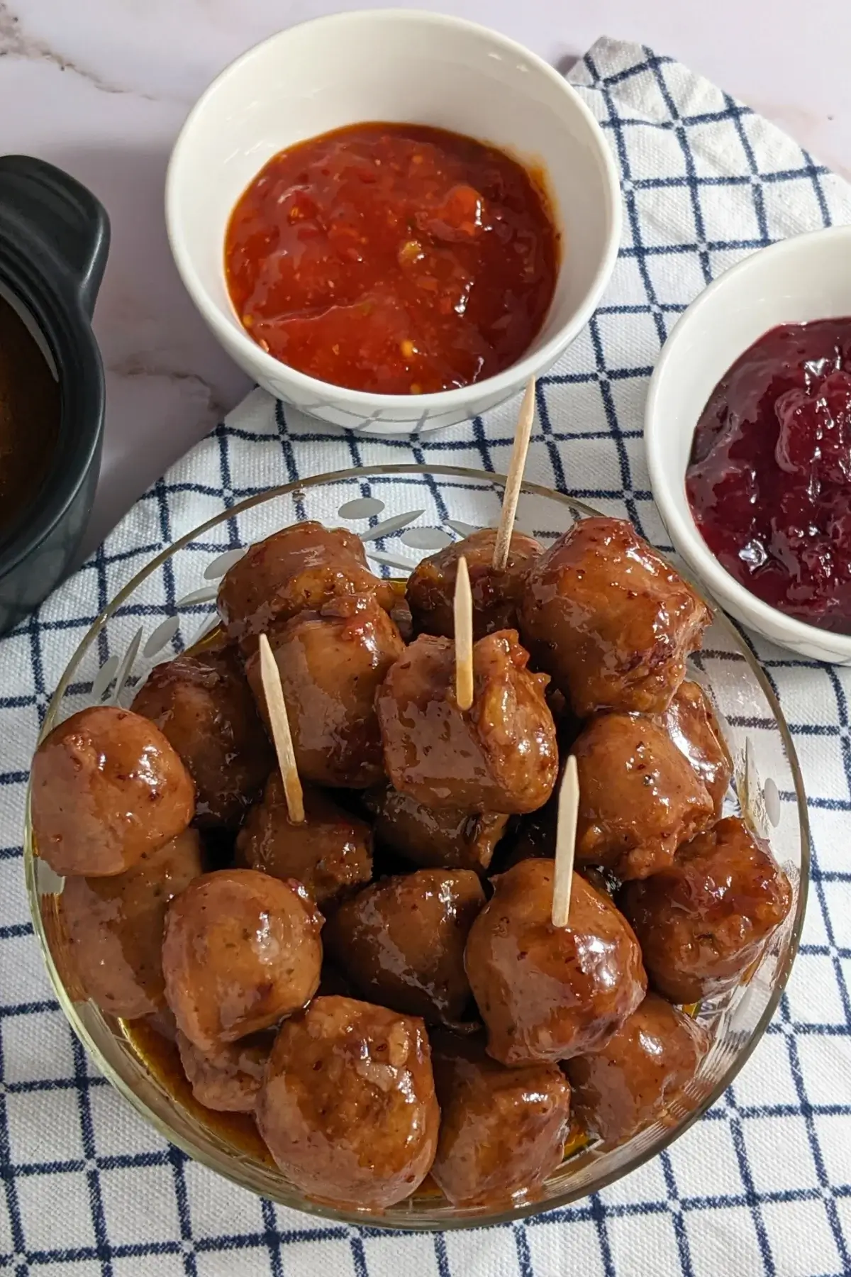 Cranberry Sausage Bites - sticky sausage appetizers made with pieces of fresh sausages, baked in the oven in a cranberry, sweet chili, soy sauce, and lime marinade.
