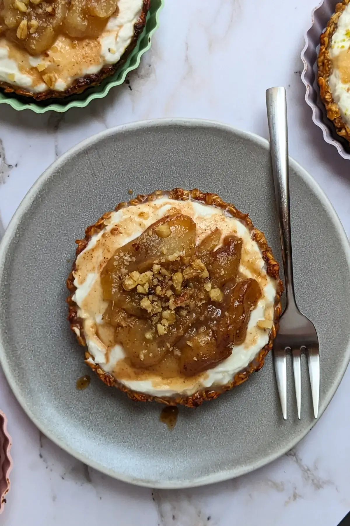 Mini Tarts With Whipped Ricotta and Poached Pears - mini tartlets made with an oat pie crust, whipped ricotta filling, and cinnamon-flavored poached pears, topped with maple syrup and crushed nuts.