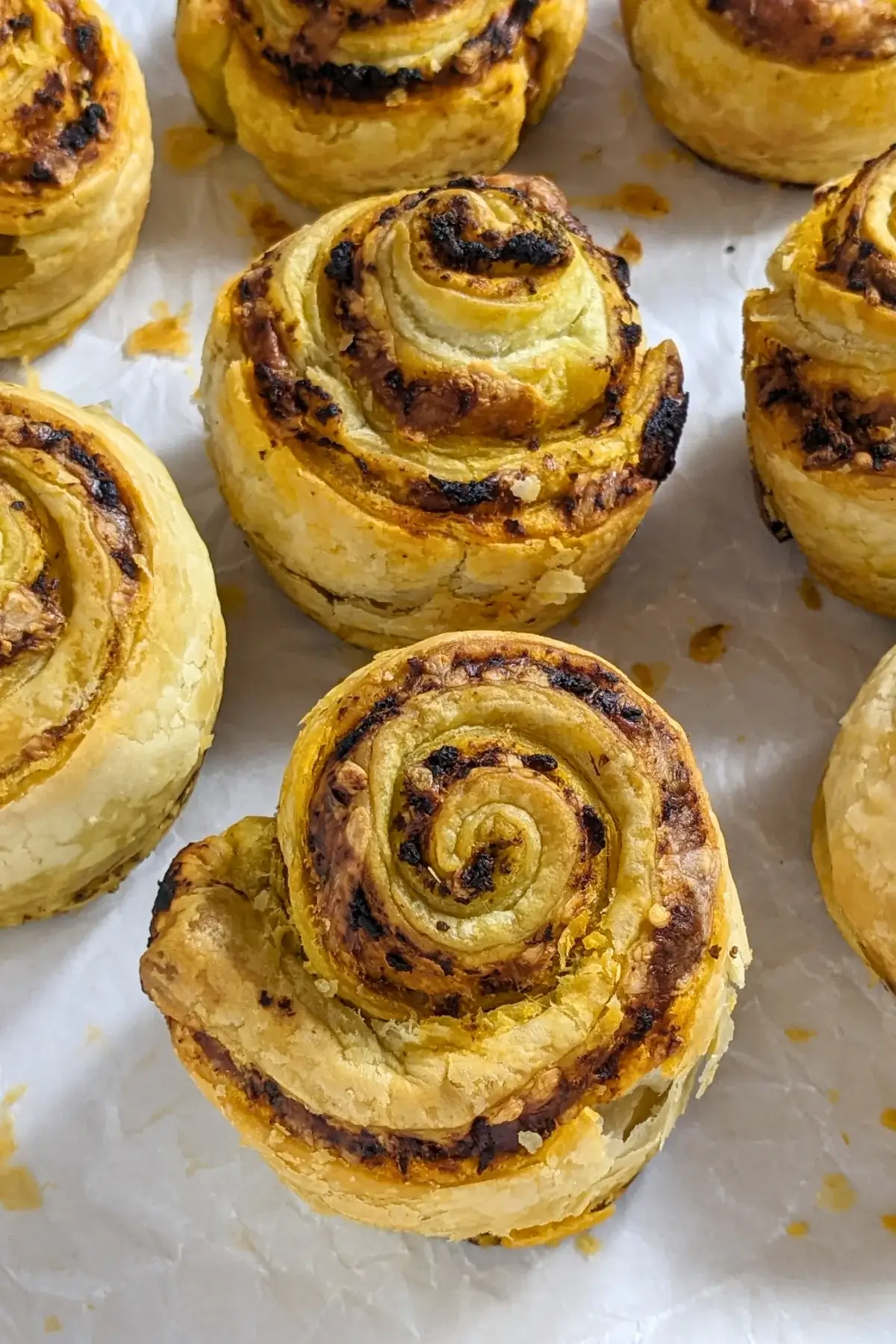 Pesto Tomato Sauce and Cheese Puff Pastry Rolls - puff pastry appetizers made with fresh puff pastry, pesto, tomato sauce, and grated cheese, rolled up and baked in a muffin tin.