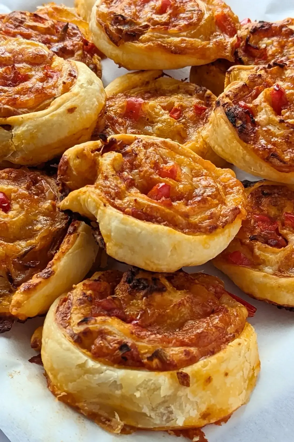 Pizza Pinwheels - Golden brown pizza pinwheels filled with tomato sauce, salami, and melted cheese.