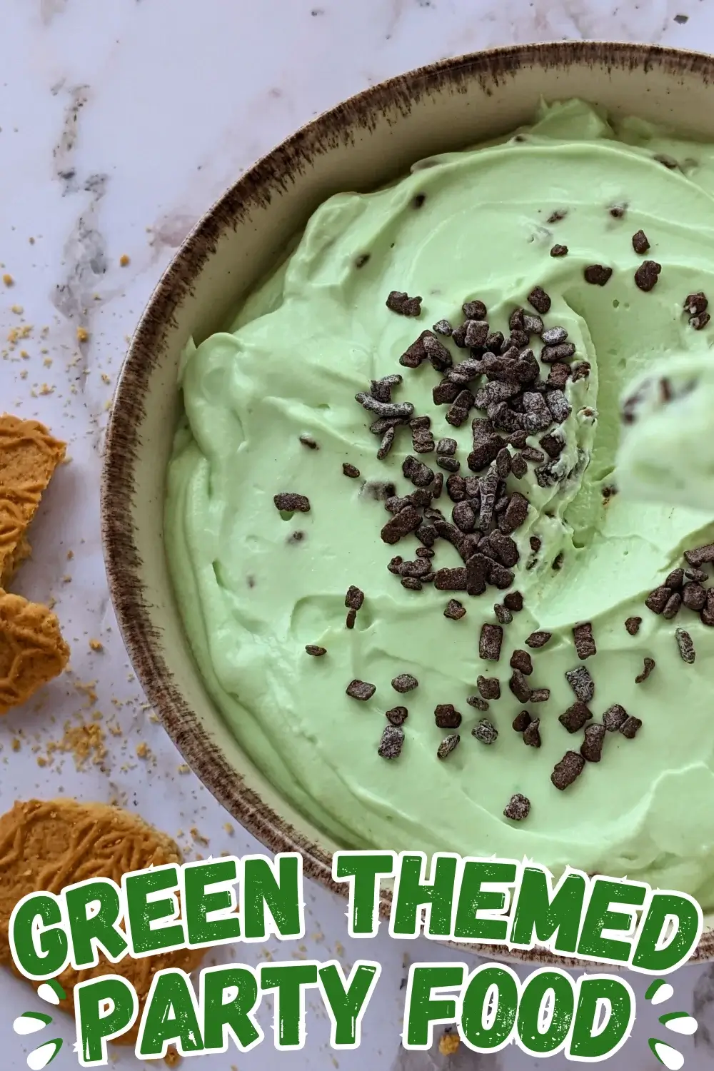 Fluffy Green-Themed Cheesecake Dessert Dip - fluffy cheesecake dip dessert made with cream cheese, heavy whipping cream, Greek yogurt, a few drops of green food coloring, and dark chocolate chips.