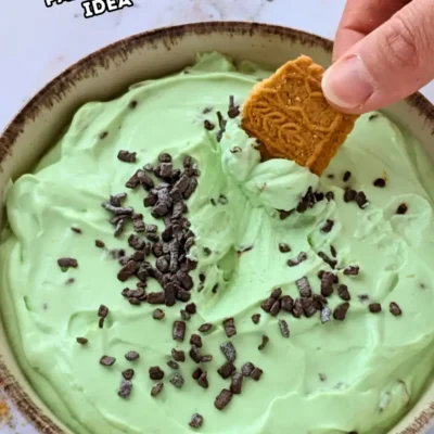 Fluffy Green-Themed Cheesecake Dessert Dip - fluffy cheesecake dip dessert made with cream cheese, heavy whipping cream, Greek yogurt, a few drops of green food coloring, and dark chocolate chips.