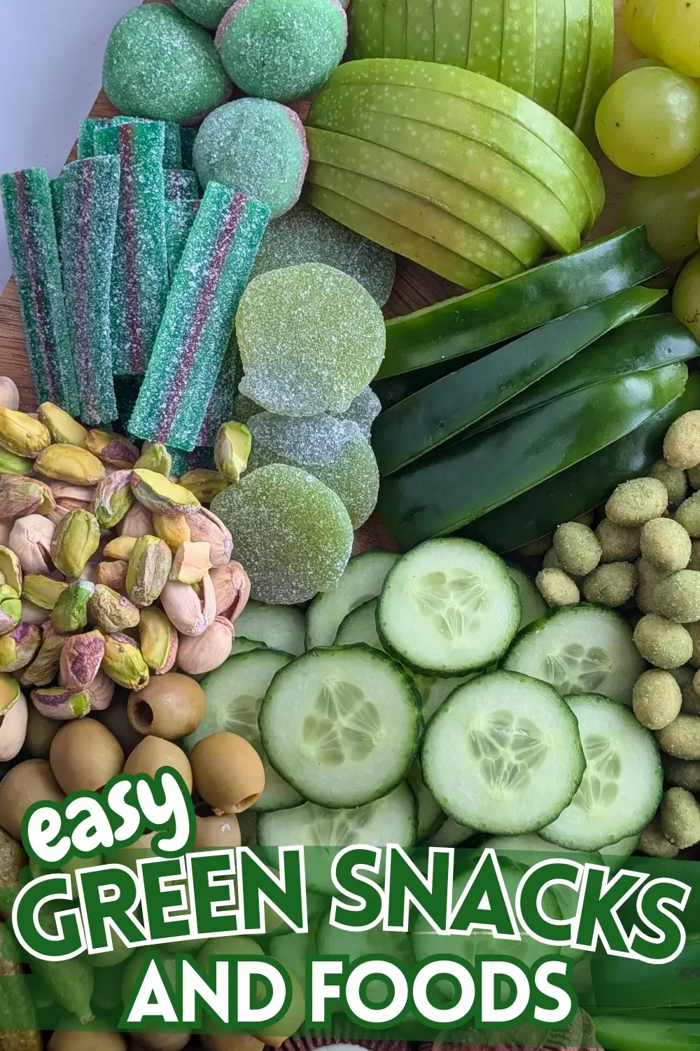 Green Food Board - Green themed party food board and snack tray with homemade tzatziki sauce and simple avocado dip; dried chives covered potato chips; crunchy wasabi coated peanuts; fresh cucumber and green capsicum; mini pickles; pistachios; olives in brine; fresh fruit like green grapes, green apples, kiwis, and green pears; and a selection of sweet snacks like green gummy candies and Domino's lime and peppermint cookies.