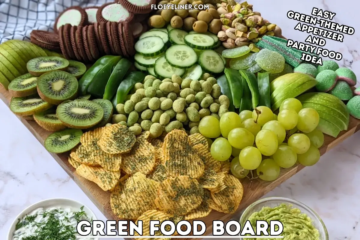 Green Food Board - Green themed party food board and snack tray with homemade tzatziki sauce and simple avocado dip; dried chives covered potato chips; crunchy wasabi coated peanuts; fresh cucumber and green bell peppers; mini pickles; pistachios; olives in brine; fresh fruit like green grapes, green apples, kiwis, and green pears; and a selection of sweet snacks like green gummy candies and Domino's lime and peppermint cookies.