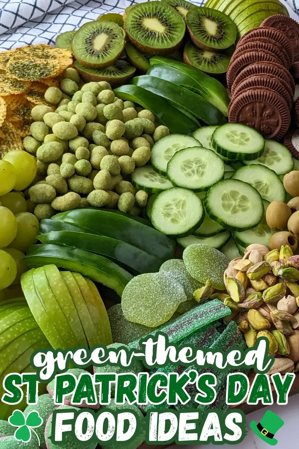 Green Food Board - Green themed party food board and snack tray with homemade tzatziki sauce and simple avocado dip; dried chives covered potato chips; crunchy wasabi coated peanuts; fresh cucumber and green capsicum; mini pickles; pistachios; olives in brine; fresh fruit like green grapes, green apples, kiwis, and green pears; and a selection of sweet snacks like green gummy candies and Domino's lime and peppermint cookies.