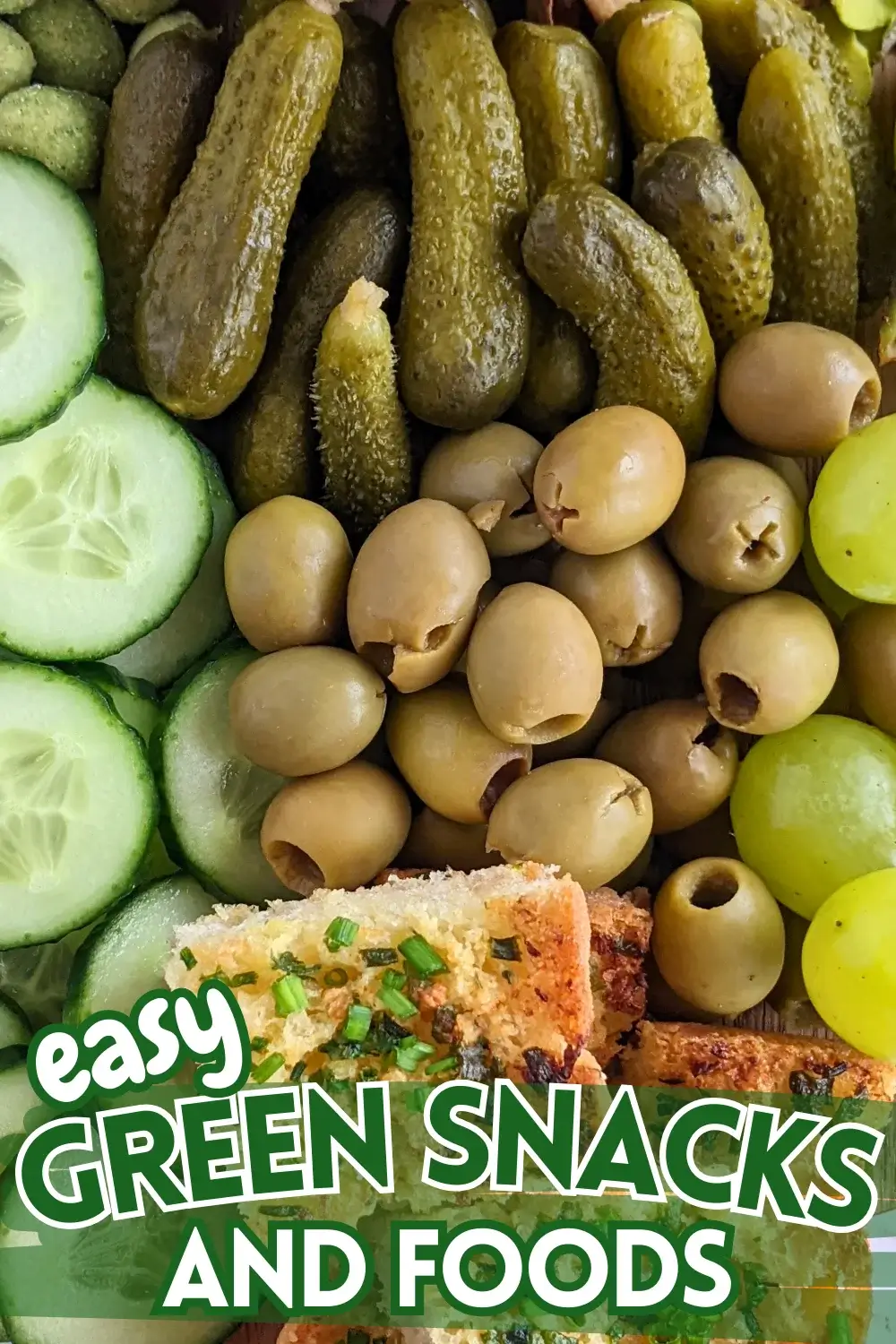 Green Snack Board - Green themed snack board and party tray with homemade garlic bread and guacamole dip, dried chives covered potato chips, fresh cucumbers, mini pickles, olives, pistachios, crunchy wasabi coated peanuts, and green grapes.