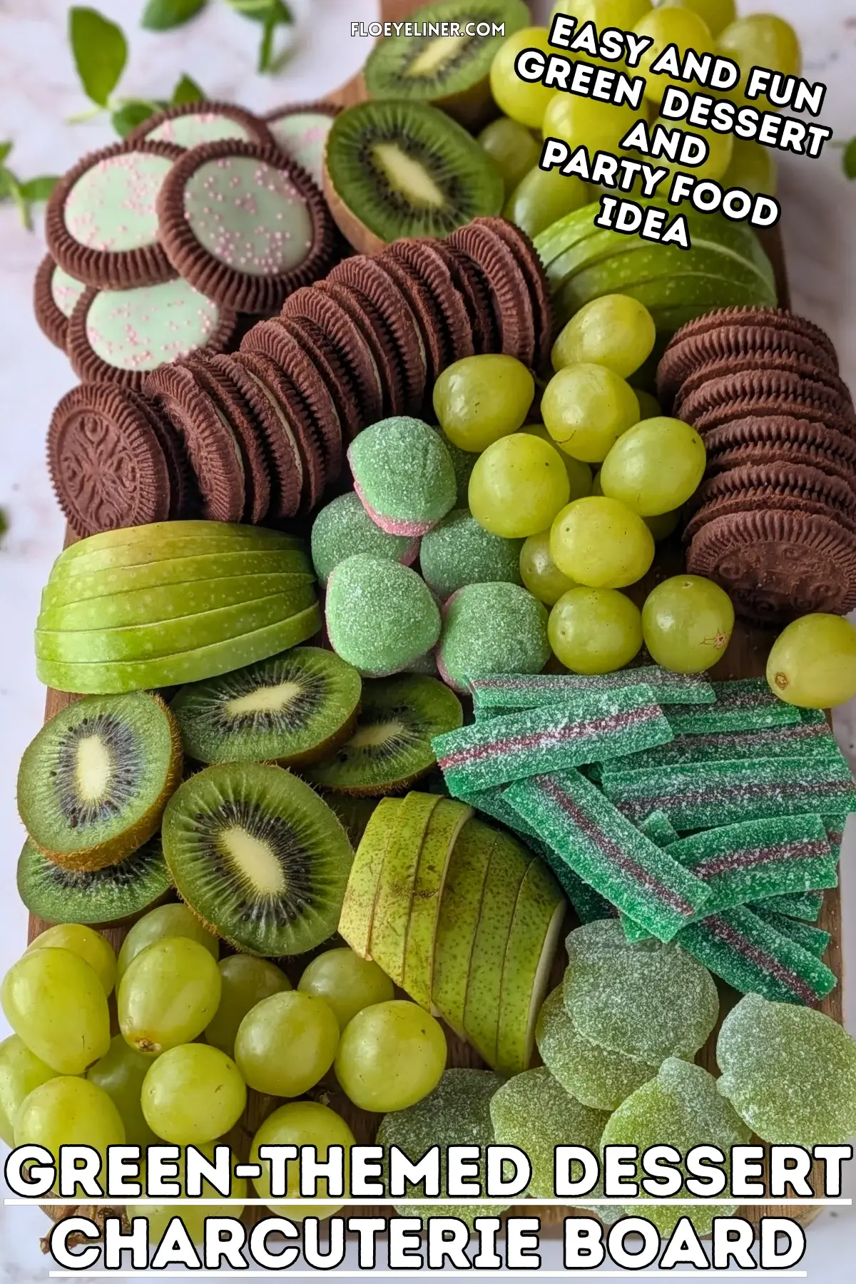 Green Themed Dessert Charcuterie Board - Green themed dessert tray with fresh fruit like green grapes, sliced green apples, kiwis, and green pears, a selection of green gummy candies, and lime flavored and peppermint filled Domino cookies.