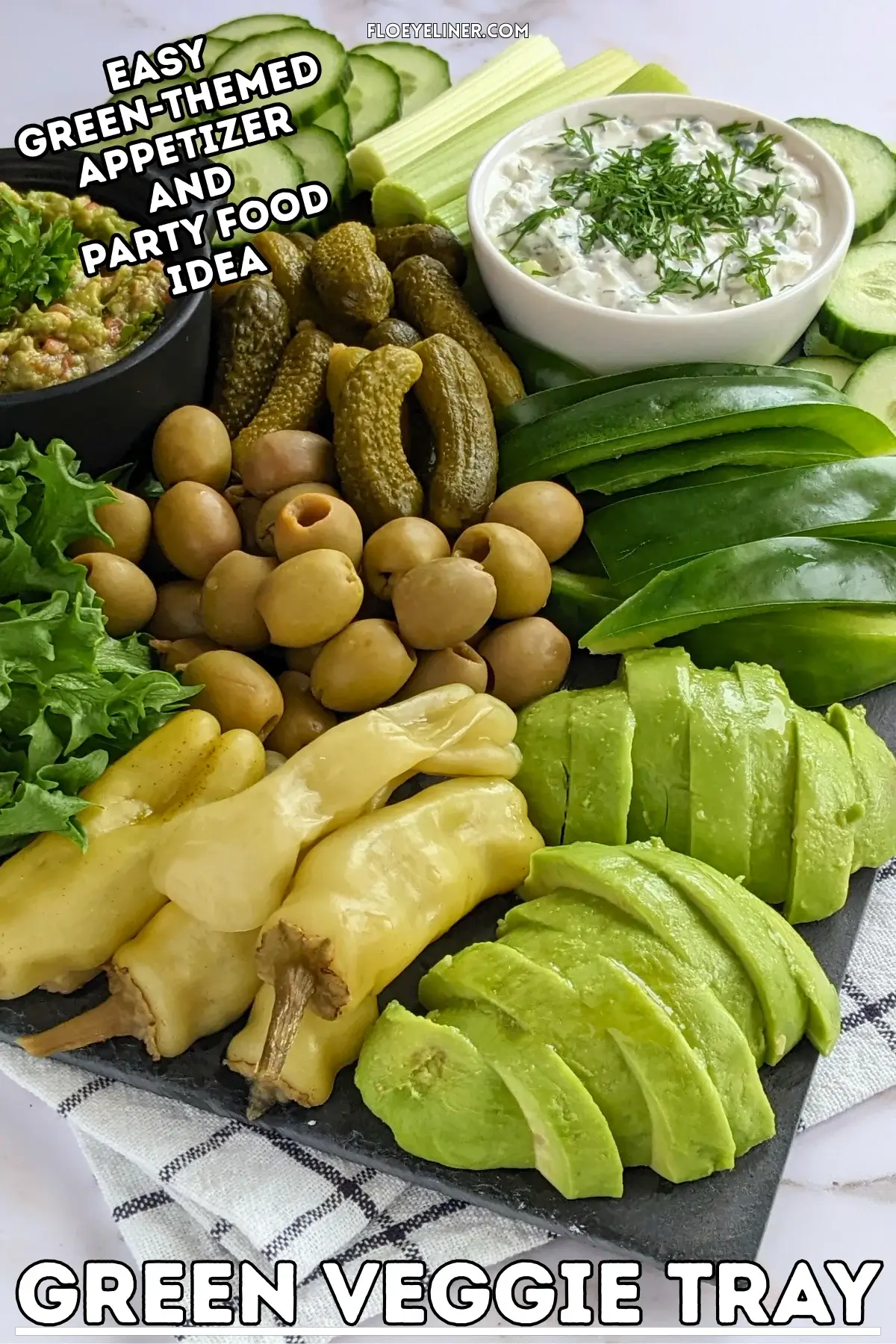 Green Veggie Tray - Green themed vegetable board with homemade guacamole and tzatziki sauce; fresh vegetables like cucumber, green bell peppers, celery, frillice lettuce, and avocado; and pickled foods like mini pickles, jalapenos, and olives in brine.