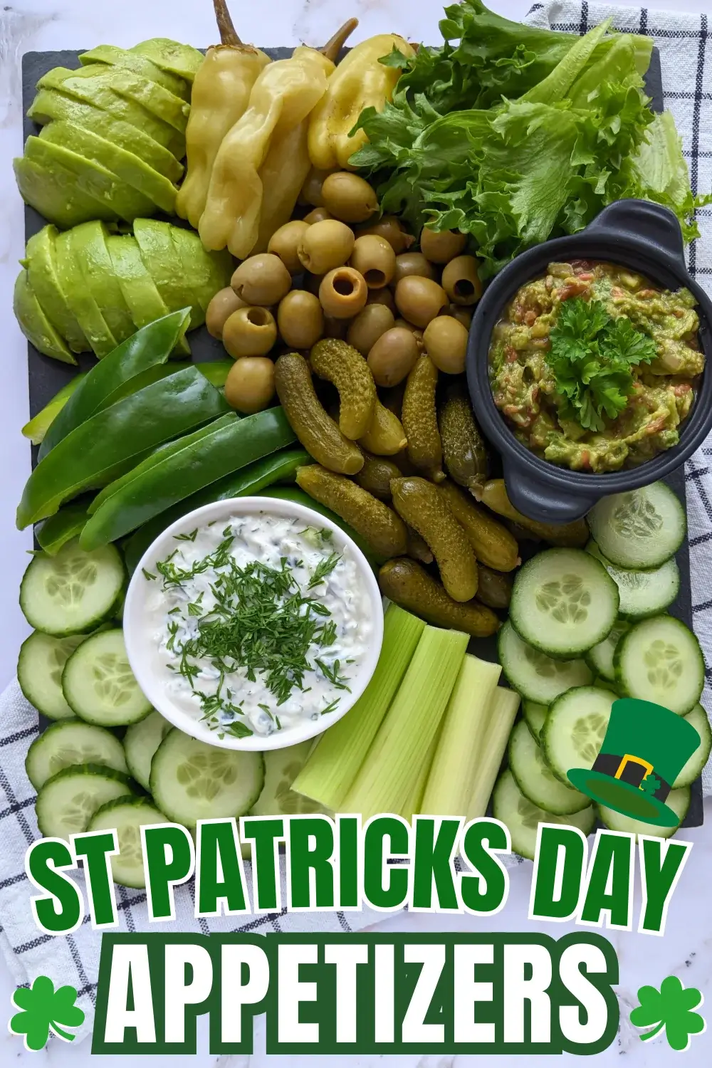 Green Veggie Tray - Green themed vegetable board with homemade guacamole and tzatziki sauce; fresh vegetables like cucumber, green capsicum, celery, frillice lettuce, and avocado; and pickled foods like mini pickles, jalapenos, and olives in brine.
