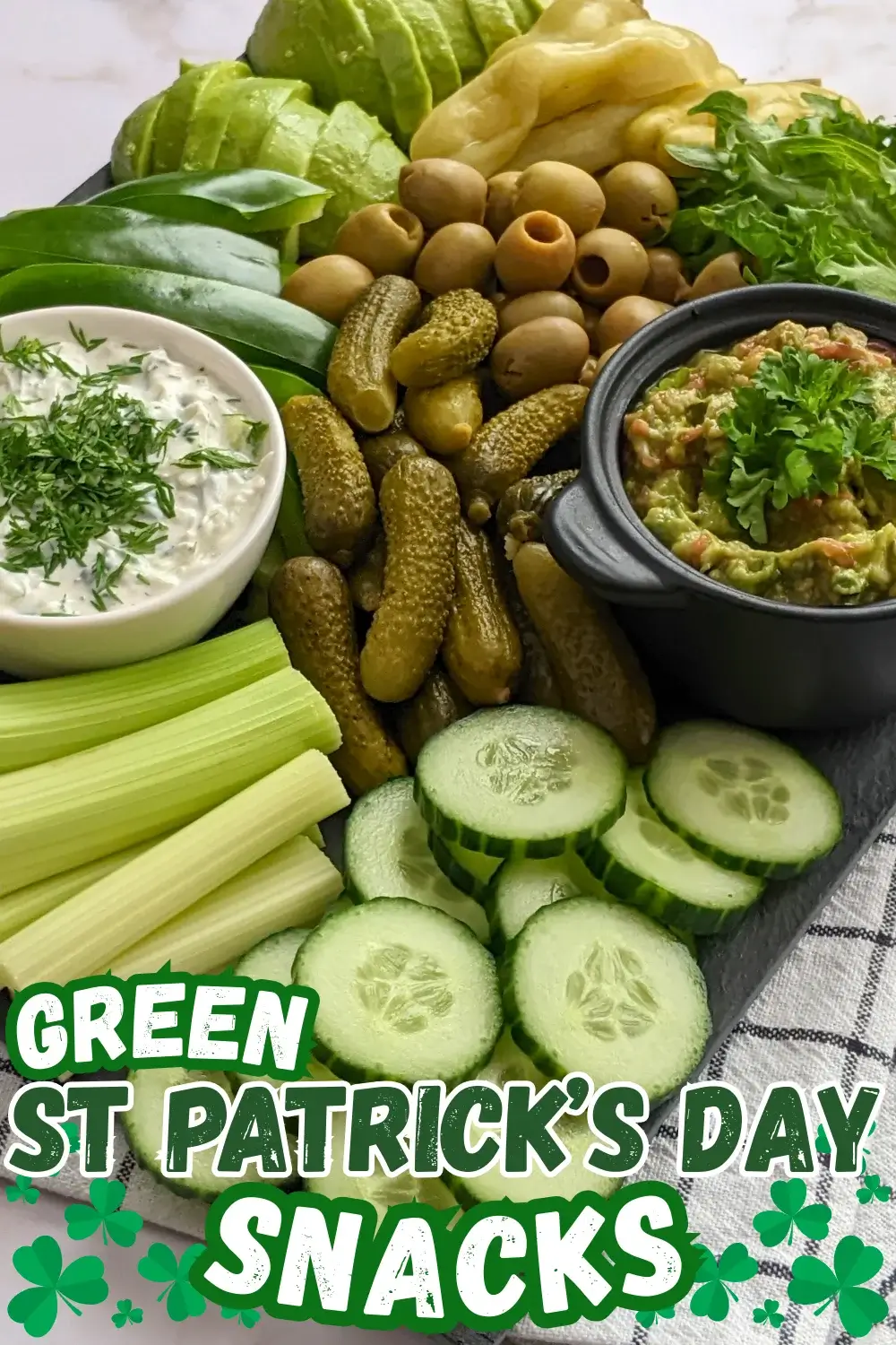 Green Veggie Tray - Green themed vegetable board with homemade guacamole and tzatziki sauce; fresh vegetables like cucumber, green capsicum, celery, frillice lettuce, and avocado; and pickled foods like mini pickles, jalapenos, and olives in brine.