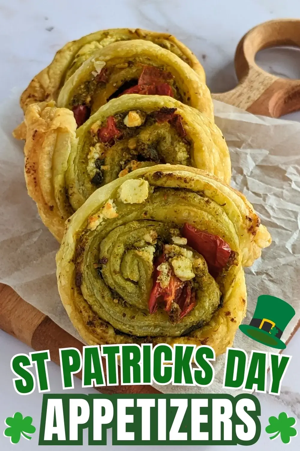 Savory pesto pinwheels made with puff pastry and filled with basil pesto, fresh cherry tomatoes, and crumbled feta.