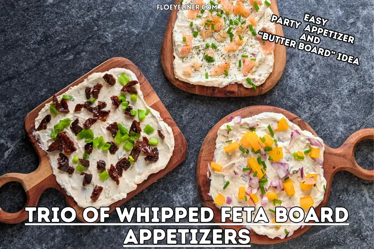 Trio of whipped feta board appetizers, one topped with smoked salmon and fresh chives, the other with sun-dried tomatoes and fresh green onions, and the third with yellow bell peppers, red onion, and fresh chives, all on a creamy feta dip base.