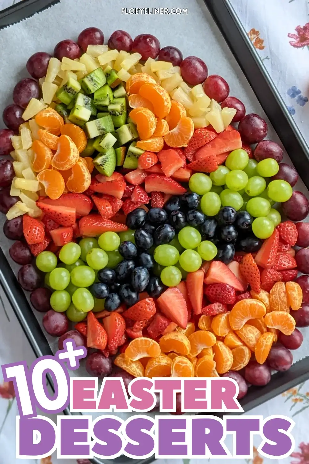 Easter Egg Fruit Tray - Easter fruit tray in an Easter egg theme, shaped with dark red grapes and filled with rows of colorful fruits like mandarin segments, kiwi pieces, green and blue grapes, strawberries, and canned pineapple pieces.