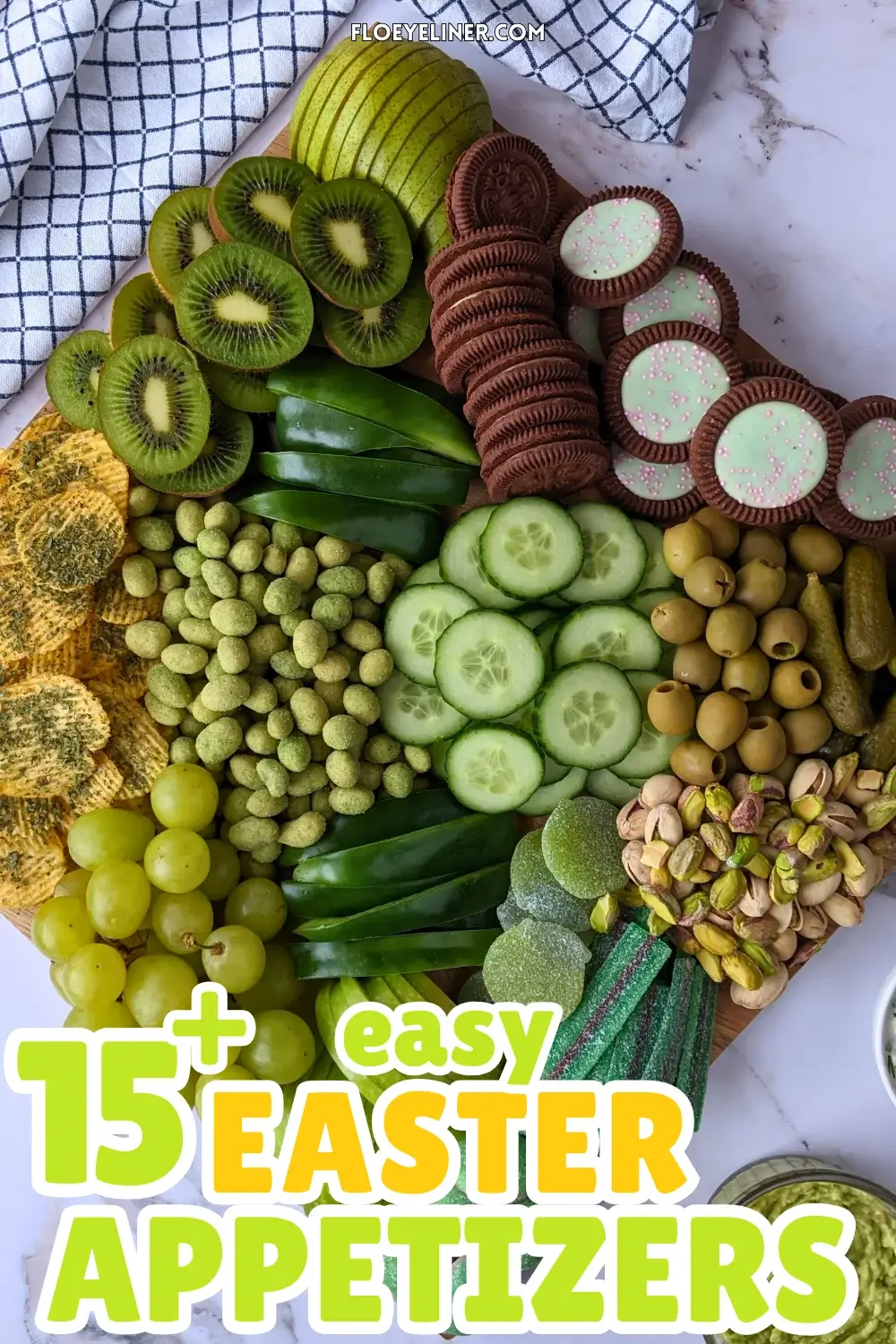 Green Food Board - Green themed party food board and snack tray with homemade tzatziki sauce and simple avocado dip; dried chives covered potato chips; crunchy wasabi coated peanuts; fresh cucumber and green bell peppers; mini pickles; pistachios; olives in brine; fresh fruit like green grapes, green apples, kiwis, and green pears; and a selection of sweet snacks like green gummy candies and Domino's lime and peppermint cookies.