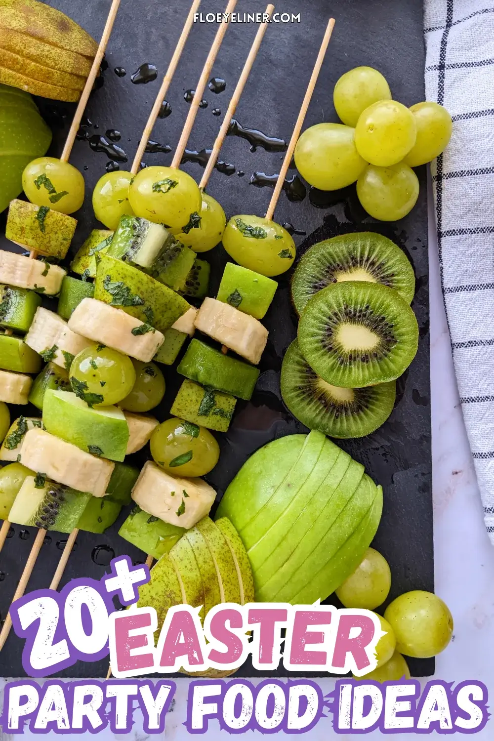 Green Fruit Tray - colorful green-themed fruit tray with green fruit kabobs featuring fruits like kiwi, green grapes, green apple, green pear, and bananas that are drizzled with a fresh mint, lime juice, and maple sryup sauce, plus slices of green apple, green pear, kiwis, and little piles of green grapes.