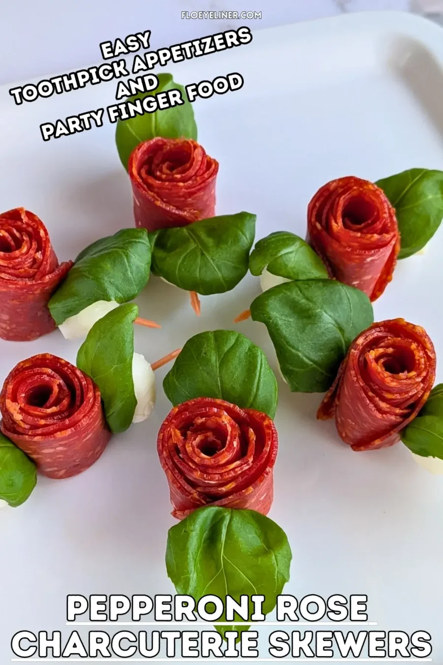 Pepperoni Rose Charcuterie Skewers - party appetizers and finger food on toothpicks made with slices of pepperoni rolled up into roses, fresh basil leaves for rose leaves, and mini mozzarella balls.