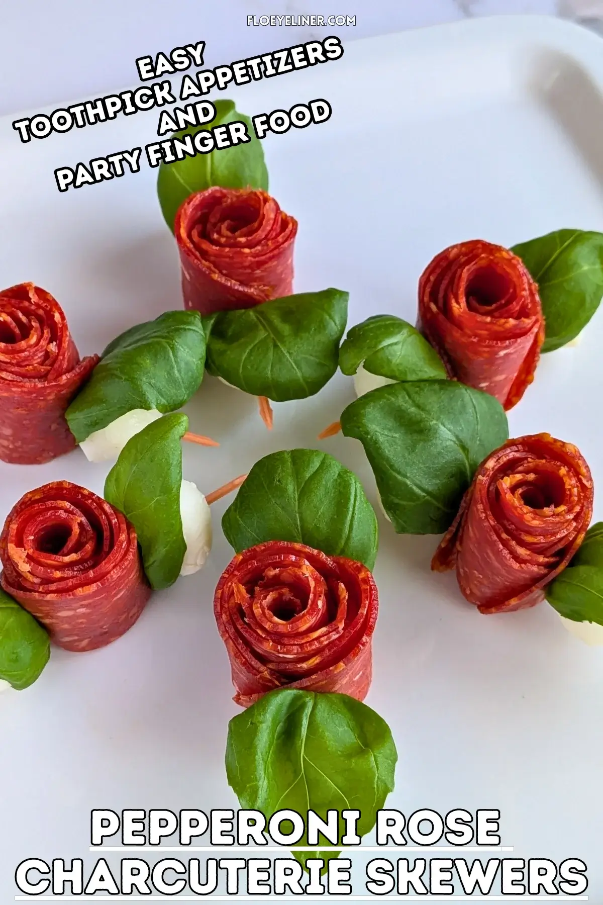 Pepperoni Rose Charcuterie Skewers - party appetizers and finger food on toothpicks made with slices of pepperoni rolled up into roses, fresh basil leaves for rose leaves, and mini mozzarella balls.