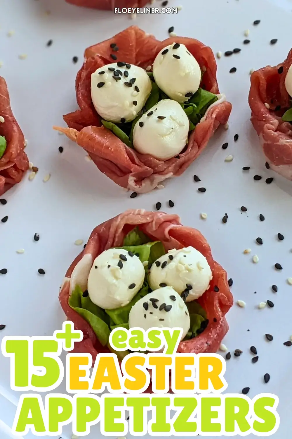 Prosciutto and Mini Mozzarella Bird Nests - easy 4-ingredient prosciutto and mozzarella appetizer with the prosciutto slices forming bird nests and the mini mozzarella balls sitting on green salad leaves as eggs, topped with black and white sesame seeds for speckles.