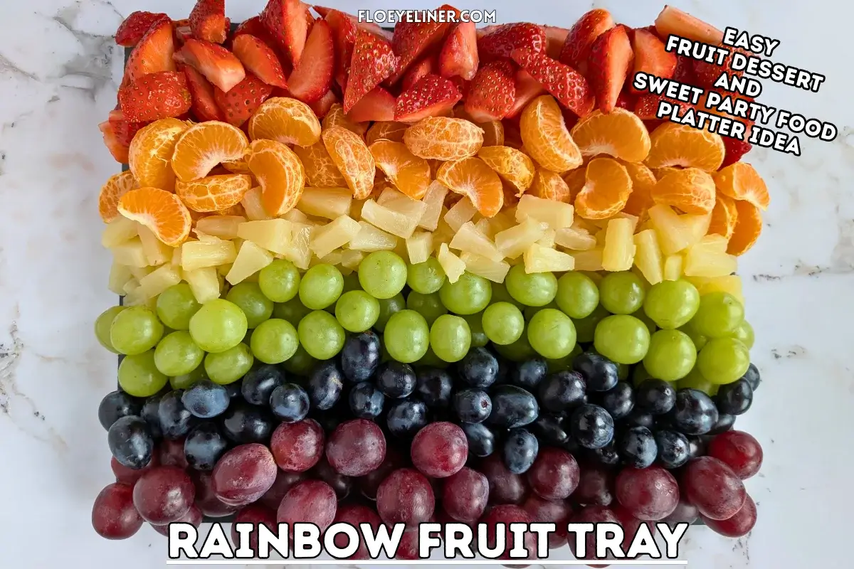 Rainbow Fruit Tray - colorful fruit platter in rainbow colors made with fruits and berries like strawberries, mandarin segments, canned pineapple pieces, green grapes, blue grapes, and dark red grapes.