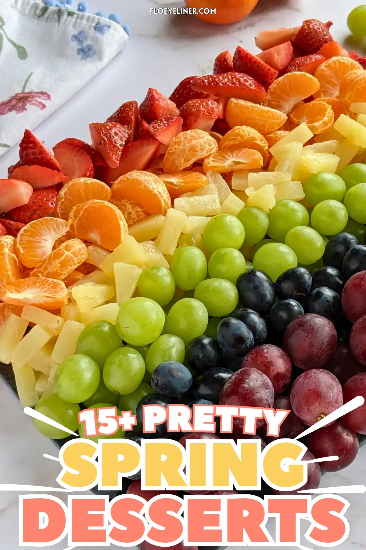 Rainbow Fruit Tray - colorful fruit platter in rainbow colors made with fruits and berries like strawberries, mandarin segments, canned pineapple pieces, green grapes, blue grapes, and dark red grapes.