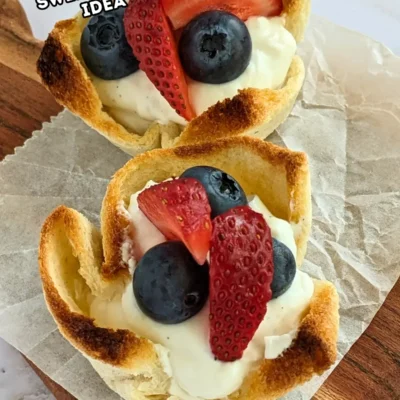 Ricotta and Mixed Berry Dessert Toast Cups - muffin-tin baked mini dessert cups made from white bread, filled with sweet ricotta and topped with fresh mixed berries like strawberries and blueberries.
