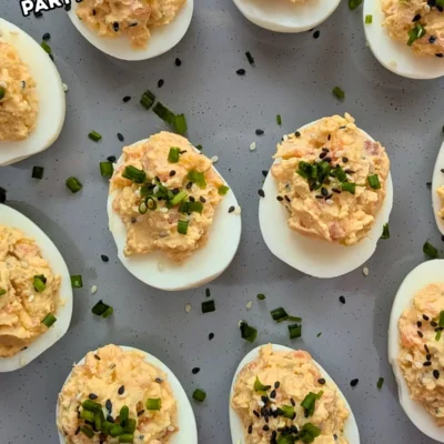 Smoked Salmon Deviled Eggs - deviled eggs filled with a creamy smoked salmon, cream cheese, sour cream, dijon mustard, and crispy dried chopped onions filling, topped with toasted sesame seeds and chopped chives.
