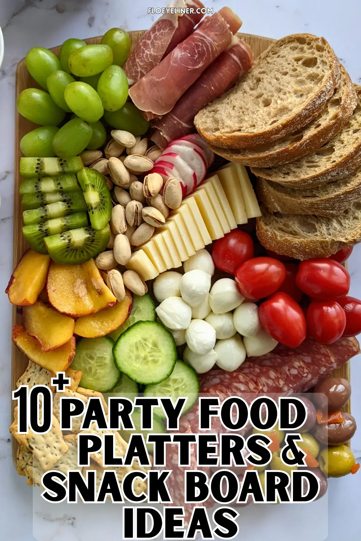 Colorful Antipasto Party Food Platter - A vibrant colorful antipasto party food platter with cured meats, marinated veggies, cheeses, olives, fruit, and ciabatta arranged on a wooden platter.