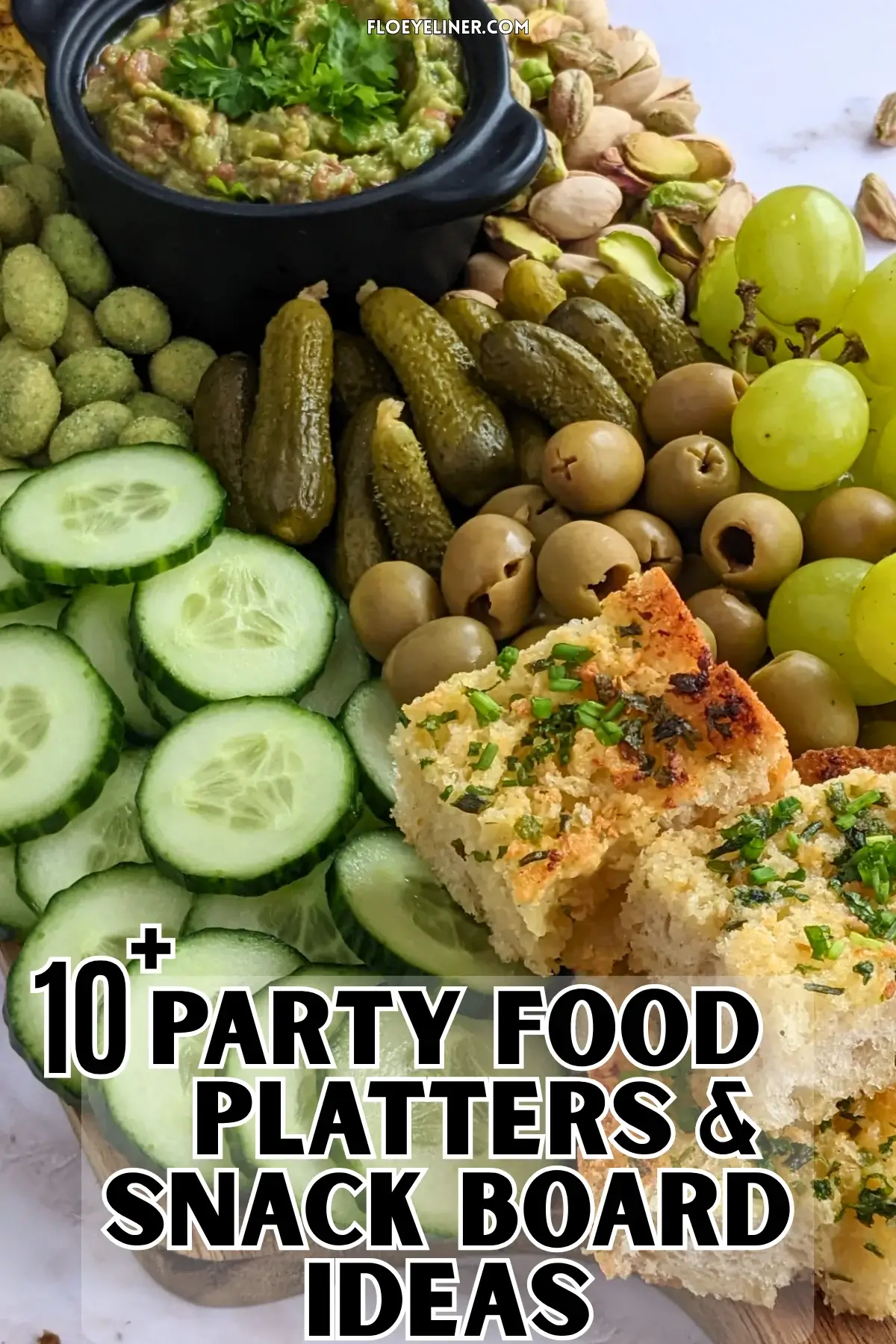 Green Snack Board - Green themed snack board and party tray with homemade garlic bread and guacamole dip, dried chives covered potato chips, fresh cucumbers, mini pickles, olives, pistachios, crunchy wasabi coated peanuts, and green grapes.