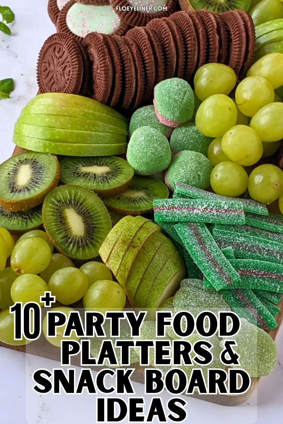 Green Themed Dessert Charcuterie Board - Green themed dessert tray with fresh fruit like green grapes, sliced green apples, kiwis, and green pears, a selection of green gummy candies, and lime flavored and peppermint filled Domino cookies.