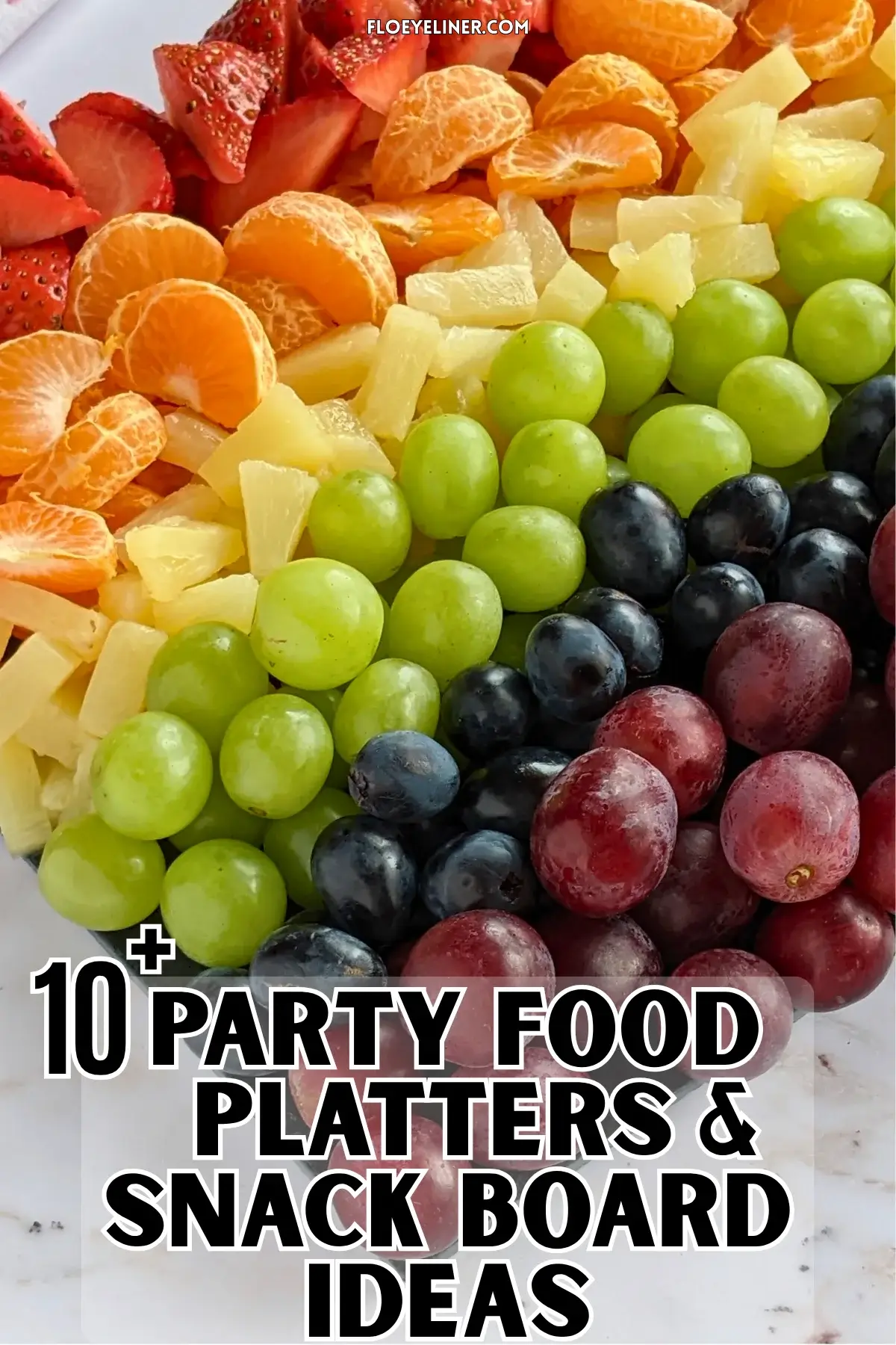 Rainbow Fruit Tray - colorful fruit platter in rainbow colors made with fruits and berries like strawberries, mandarin segments, canned pineapple pieces, green grapes, blue grapes, and dark red grapes.