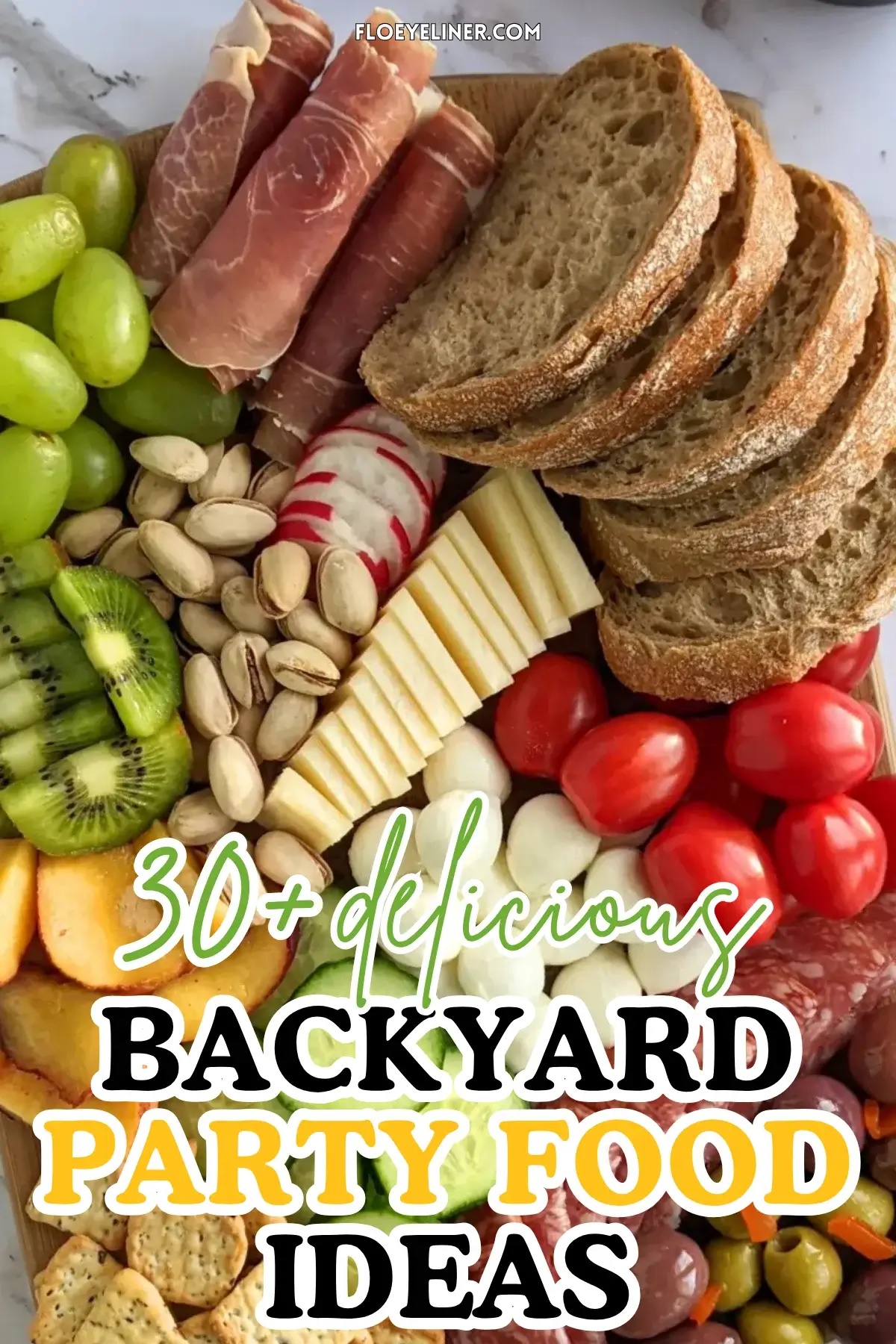 Colorful Antipasto Party Food Platter - A vibrant colorful antipasto party food platter with cured meats, marinated veggies, cheeses, olives, fruit, and ciabatta arranged on a wooden platter.