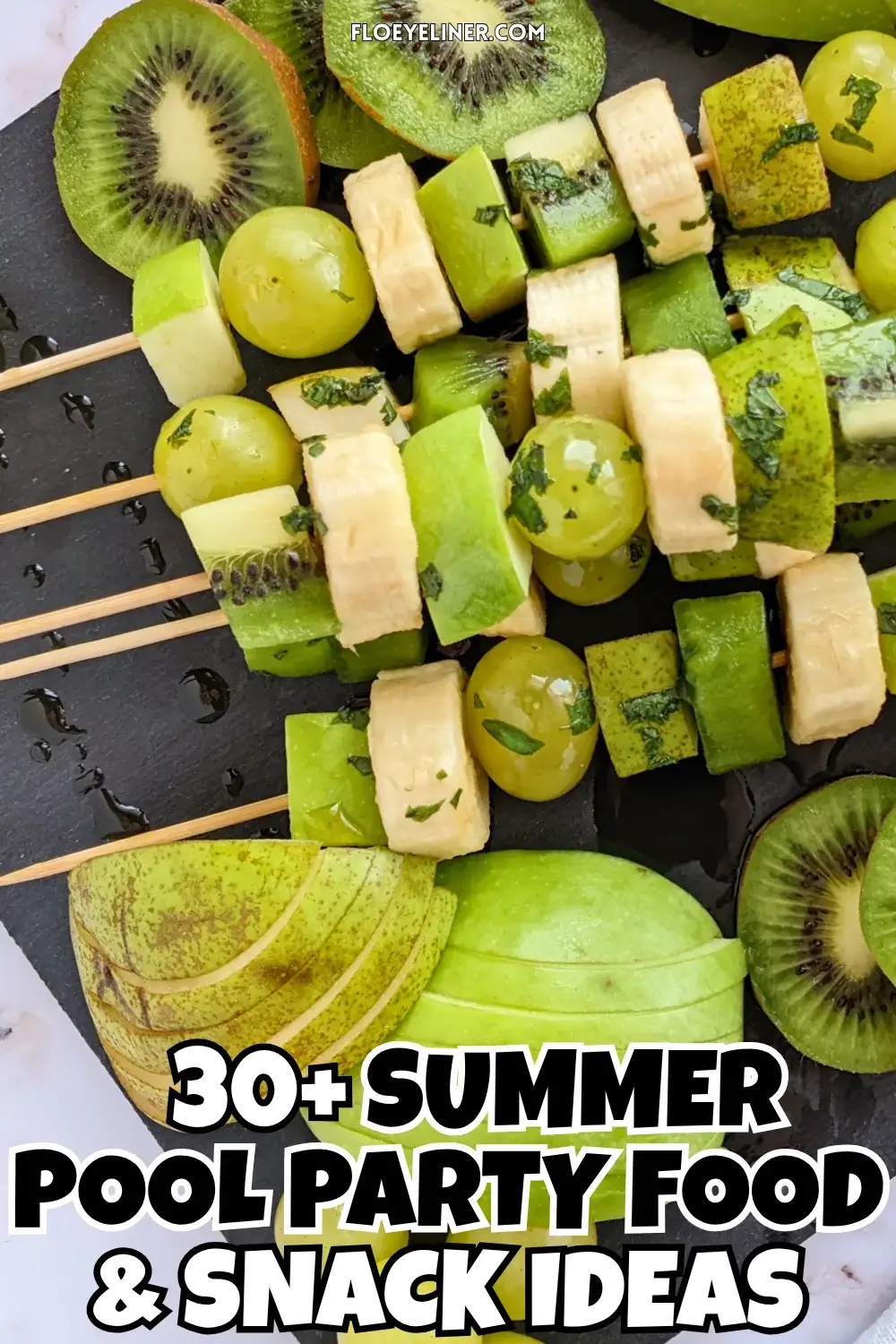 Green Fruit Tray - colorful green-themed fruit tray with green fruit kabobs featuring fruits like kiwi, green grapes, green apple, green pear, and bananas that are drizzled with a fresh mint, lime juice, and maple sryup sauce, plus slices of green apple, green pear, kiwis, and little piles of green grapes.