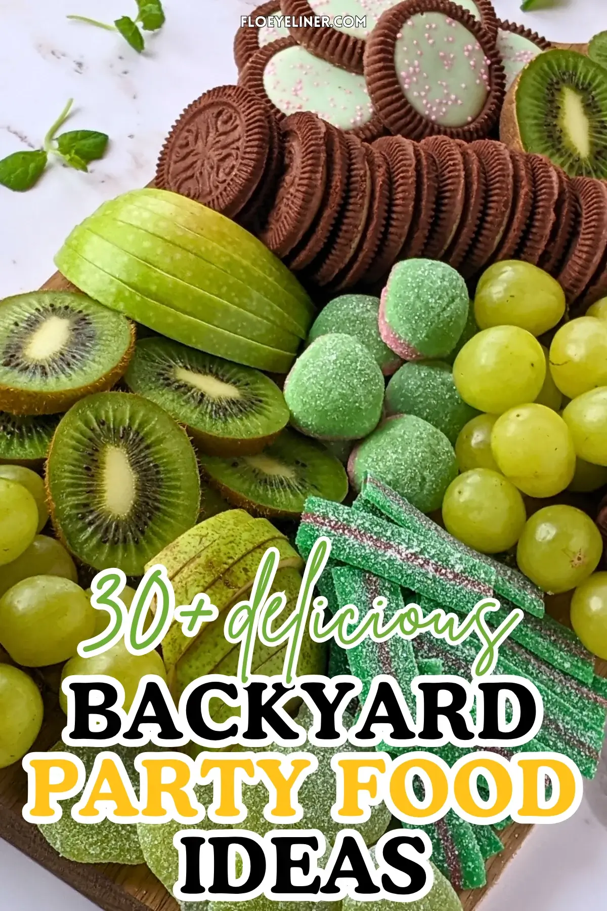 Green Themed Dessert Charcuterie Board - Green themed dessert tray with fresh fruit like green grapes, sliced green apples, kiwis, and green pears, a selection of green gummy candies, and lime flavored and peppermint filled Domino cookies.