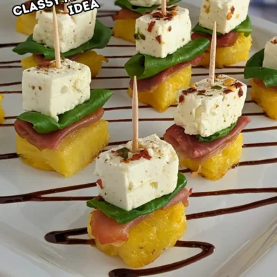 Grilled Pineapple and Marinated Feta Toothpick Appetizers - colorful fruit and cheese skewers made with fresh basil leaves nestled between prosciutto topped grilled pineapple and chili-thyme oil marinated feta cubes on toothpicks.