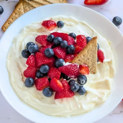 Mixed Berry Cheesecake Dessert Dip - fluffy cheesecake dip dessert made with cream cheese, heavy whipping cream, Greek yogurt, and topped with fresh strawberries and blueberries.